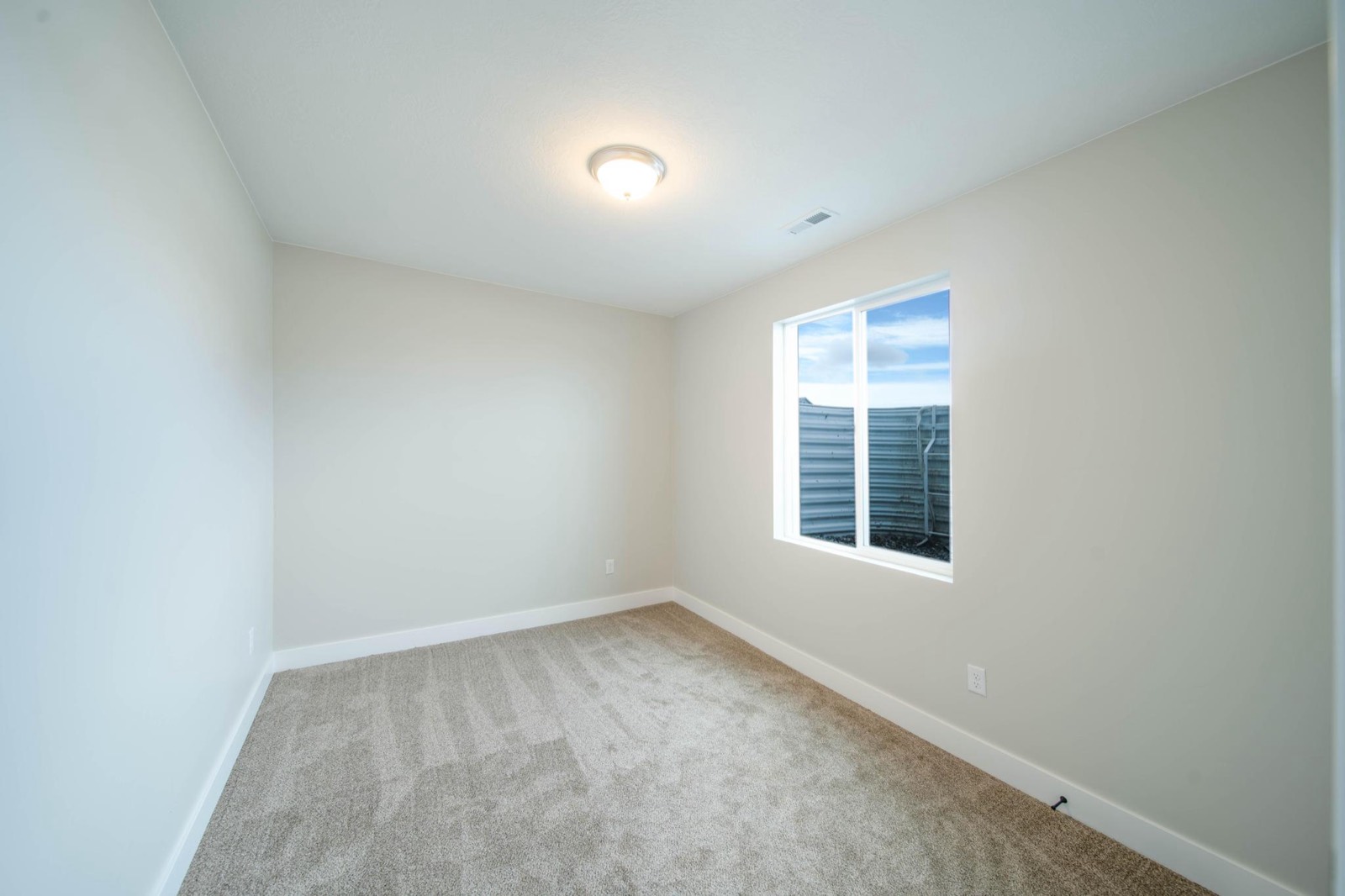 Finished basement room with clean trim and carpet