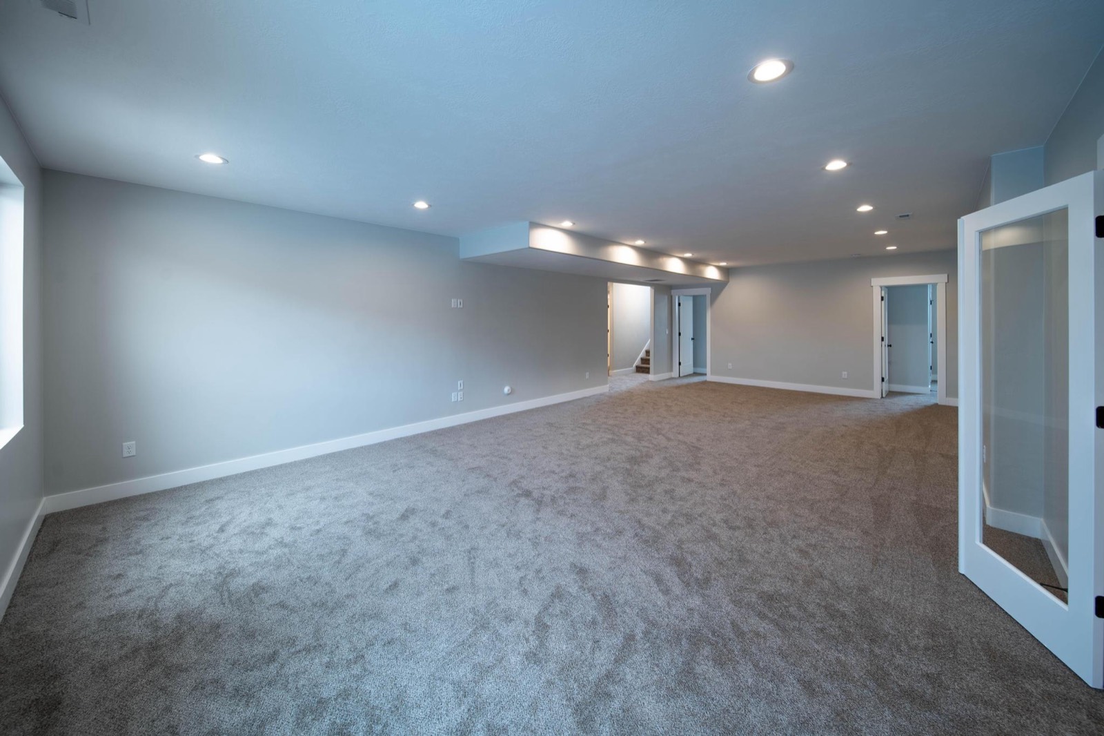Finished basement space with clean drywall, trim, and carpet