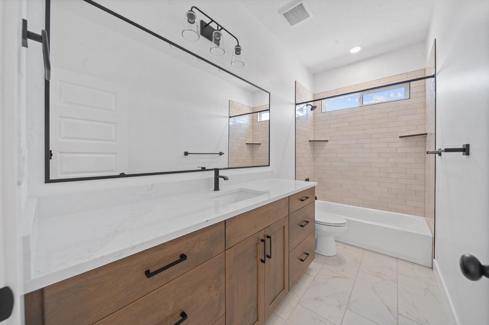Guest bathroom with a new vanity, mirror, and fixtures
