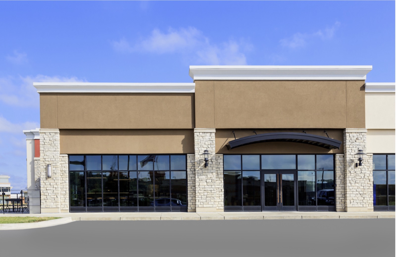 Commercial storefront with stone columns and floor-to-ceiling glass