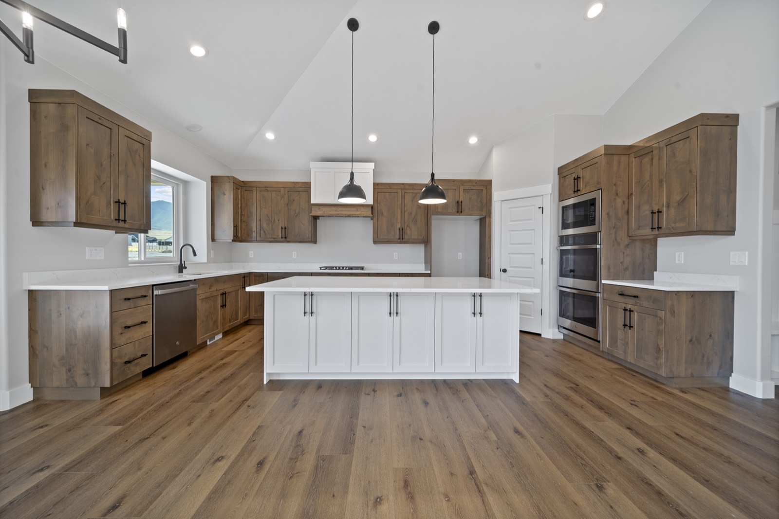 Remodeled kitchen with new cabinets, countertops, and modern lighting